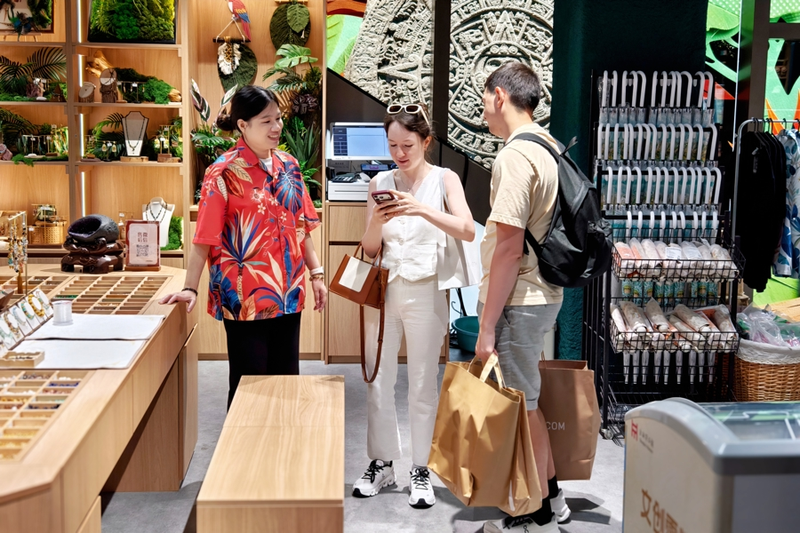 Dos turistas internacionales eligen recuerdos en una tienda ubicada en Huaihai Road, Shanghai.png