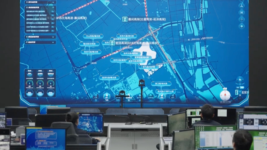 El personal de un centro de control supervisa el flujo del tráfico en una gran pantalla que muestra un mapa de la ciudad..png