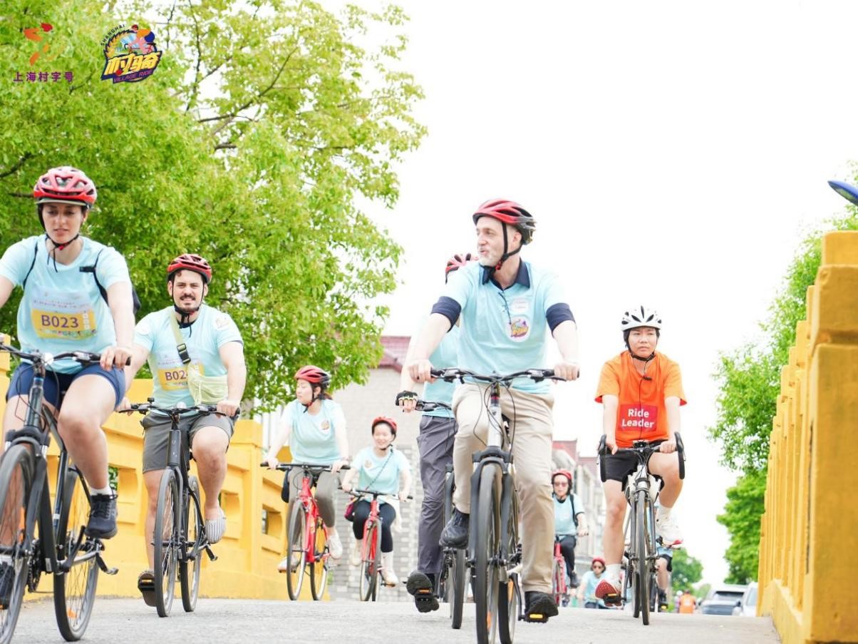 Varios extranjeros recorren en bicicleta los pintorescos paisajes rurales del pueblo de Zhuqiao, en la Nueva Área de Pudong, el 7 de junio.jpg
