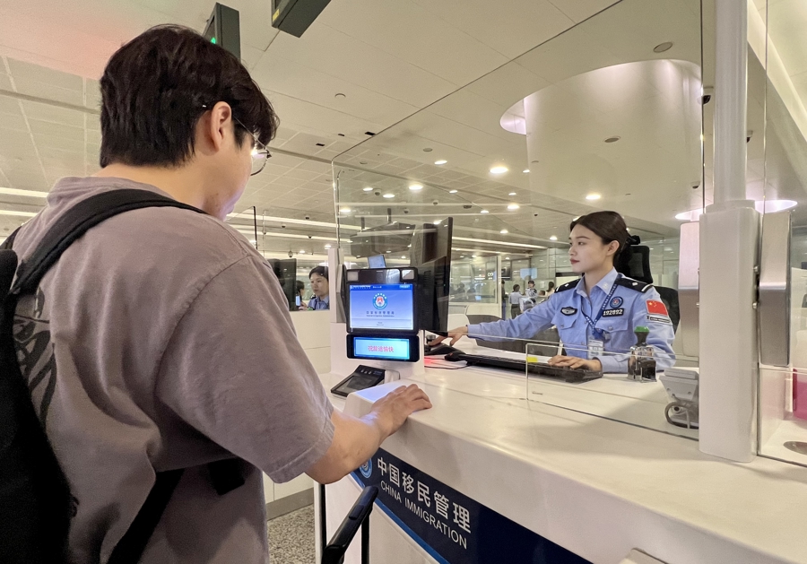 Una funcionaria de inmigración de Shanghai se encarga de la inspección fronteriza de los viajeros.jpg