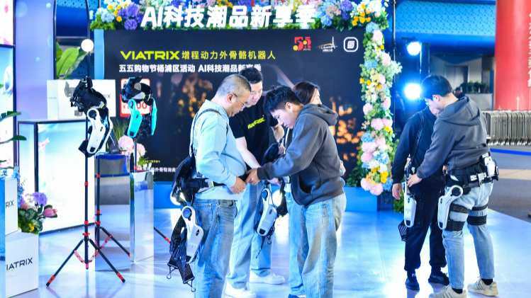 Los visitantes se prueban exoesqueletos portátiles en un evento sobre tecnología de IA celebrado en Wujiaochang, en el distrito de Yangpu..jpeg