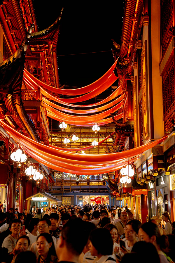 Las multitudes llenan los callejones iluminados por linternas del Jardín Yuyuan.png