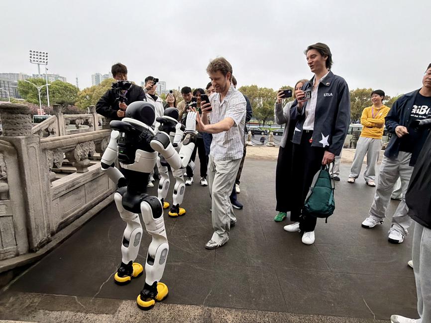 La delegación juvenil estadounidense interactúa con los robots humanoides de AgiBot en la Universidad del Deporte de Shanghai el 13 de abril..jpeg