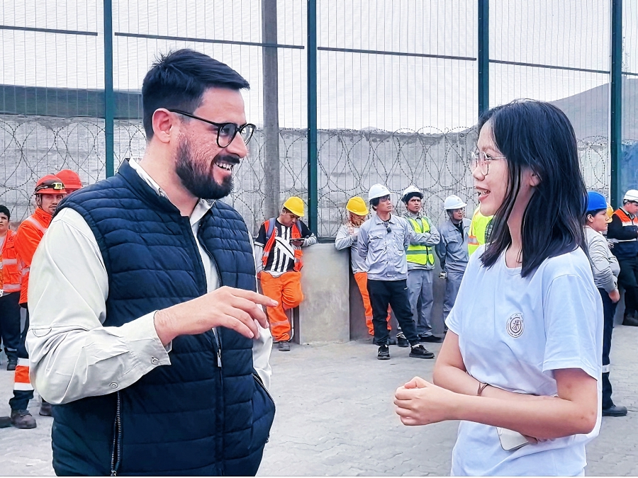 Una estudiante de la Universidad Jiaotong de Shanghai charla con un empleado local..jpeg