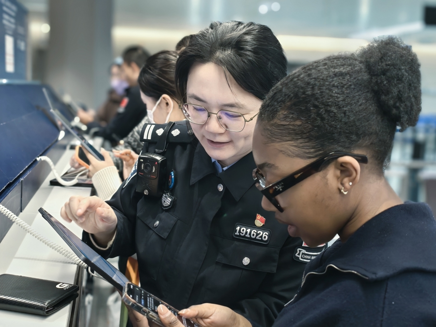 Una funcionaria de inmigración del Aeropuerto Internacional Hongqiao de Shanghai ayuda a una viajera a completar la tarjeta de llegada digital el 28 de diciembre de 2025..jpg