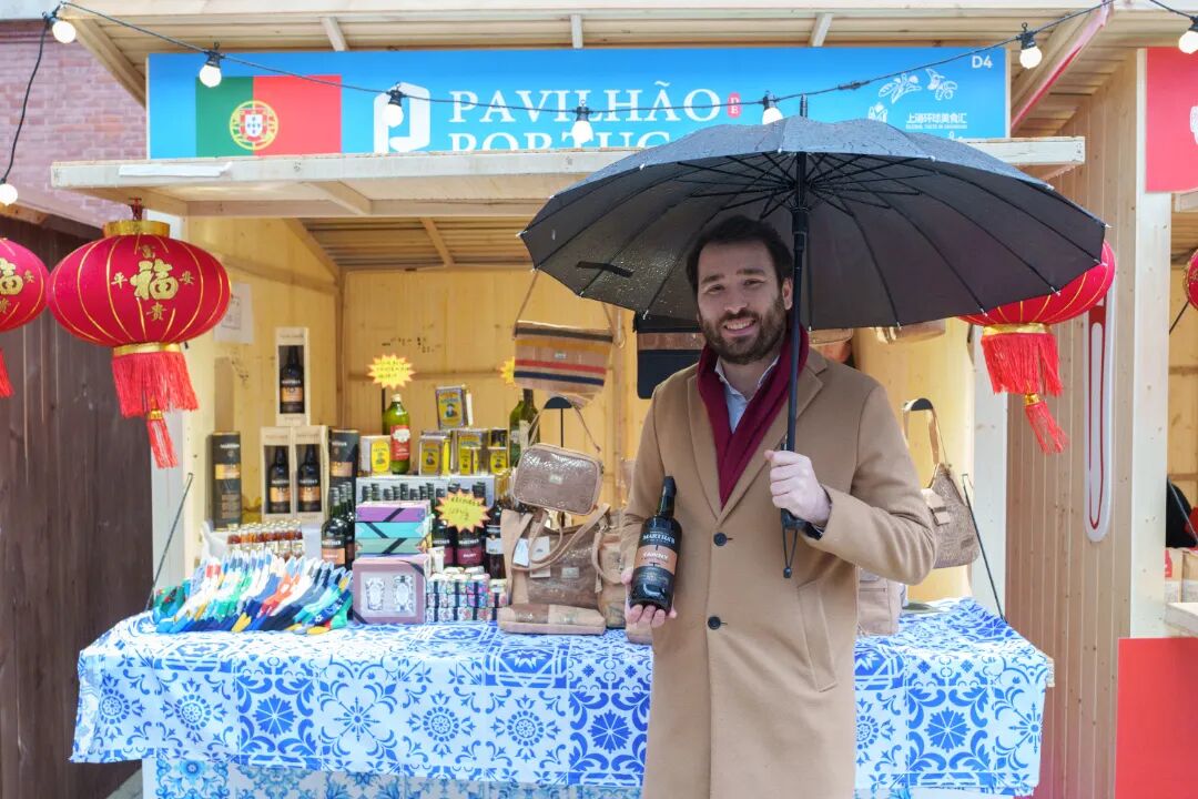 Luis Costa, consejero económico y comercial de Portugal en Shanghai, presenta con orgullo una botella de vino portugués en la feria..jpg