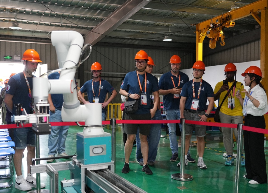 Los competidores de Luxemburgo observan equipos robóticos en un centro de capacitación de la Escuela de Formación Profesional en Construcción Urbana de Shanghai el 22 de septiembre.jpg