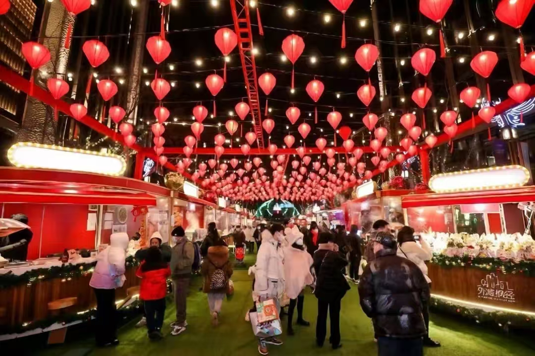 Visitantes pasean por un mercado del Centro Financiero del Bund adornado con festivos farolillos rojos.jpg