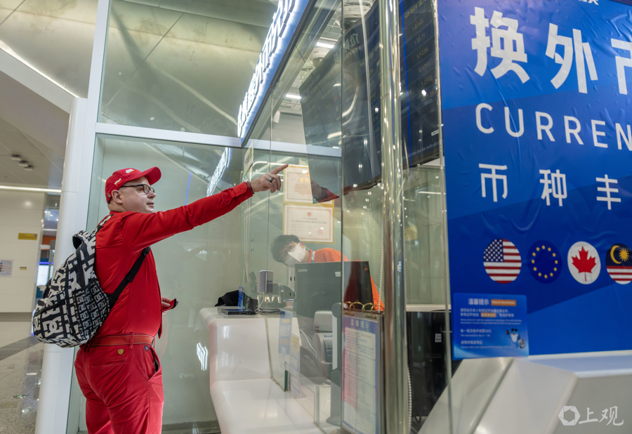 Un visitante polaco en la oficina de cambio de divisas en la estación de la Terminal 2 del aeropuerto de Hongqiao del Metro de Shanghai..jpg