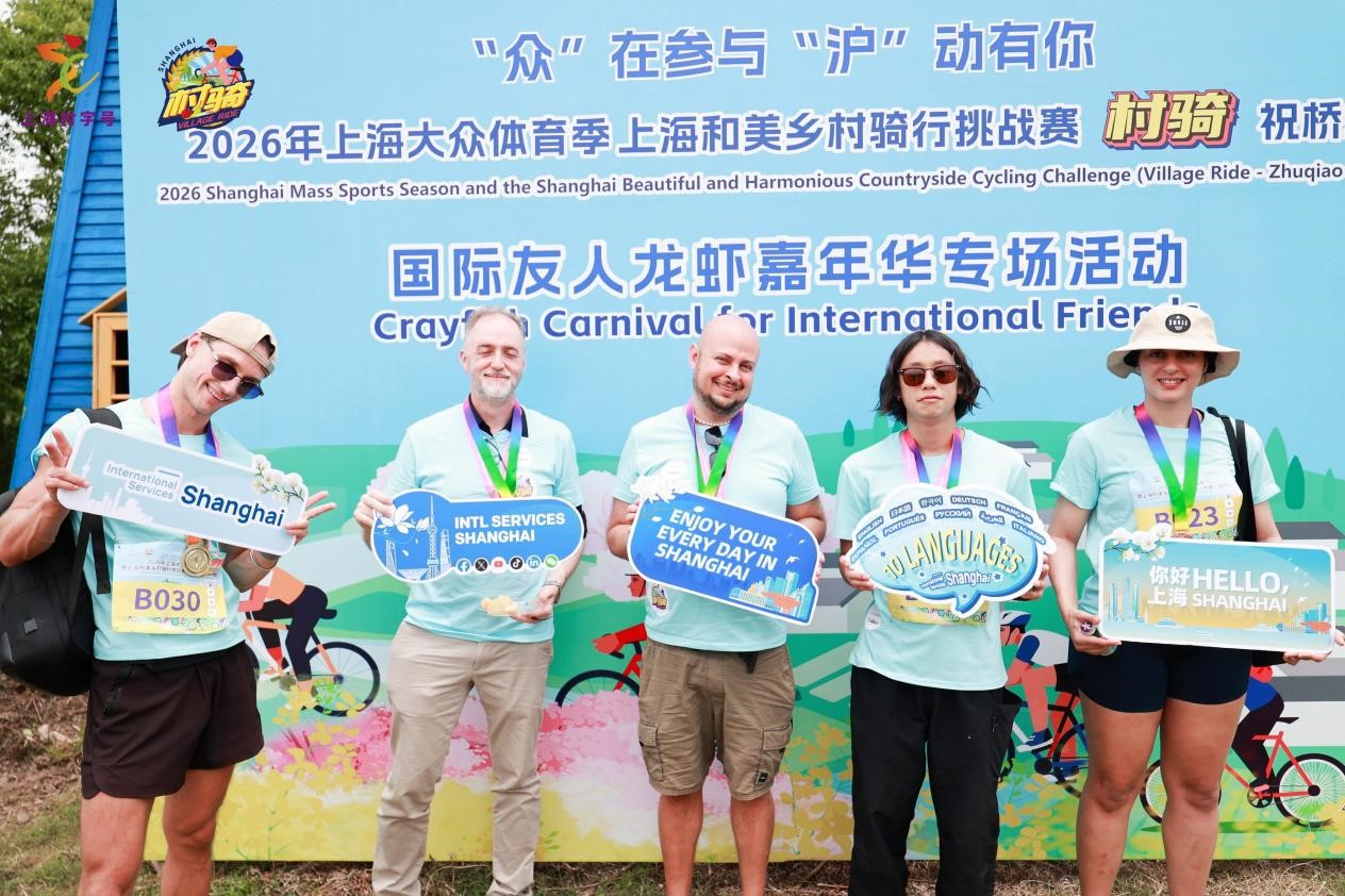 Ciclistas internacionales posan para una foto de grupo en la meta.jpg