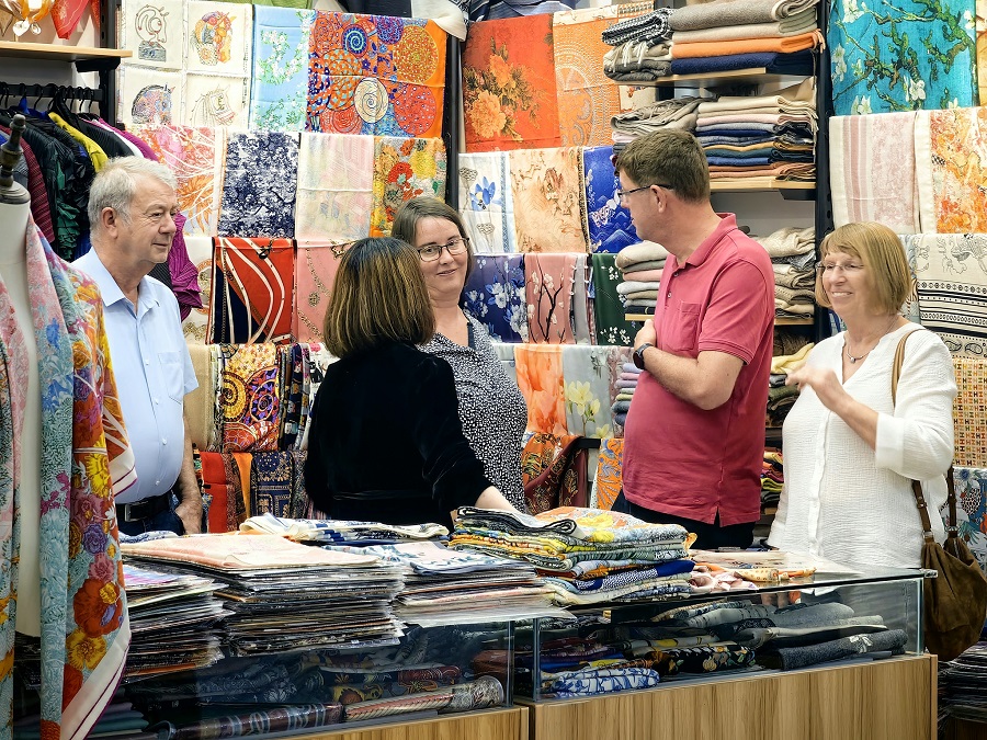 Los turistas examinan telas en el mercado..jpg