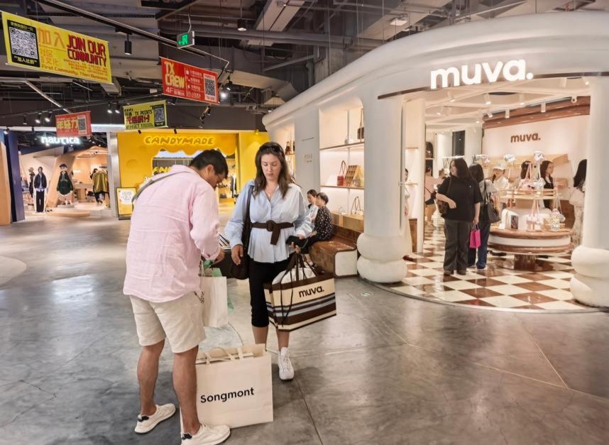 Compradores pasean con bolsas de marcas de moda chinas por Middle Huaihai Road, en Shanghai..jpg
