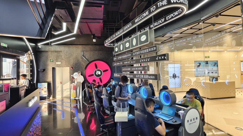Los clientes visitan una cafetería Luckin Coffee con temática de EDward Gaming en Shanghai.jpg