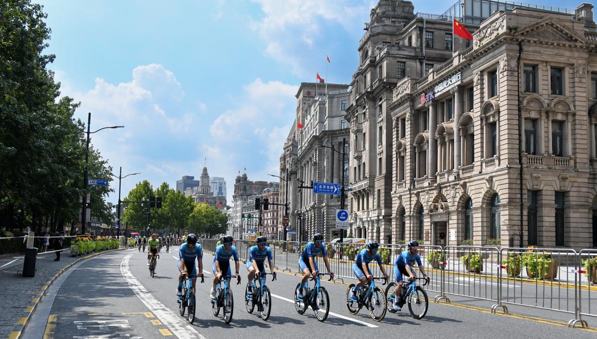 Un desfile de ciclistas, con atletas representando a todos los equipos participantes, recorre el emblemático Bund, marcando el inicio del evento..jpeg