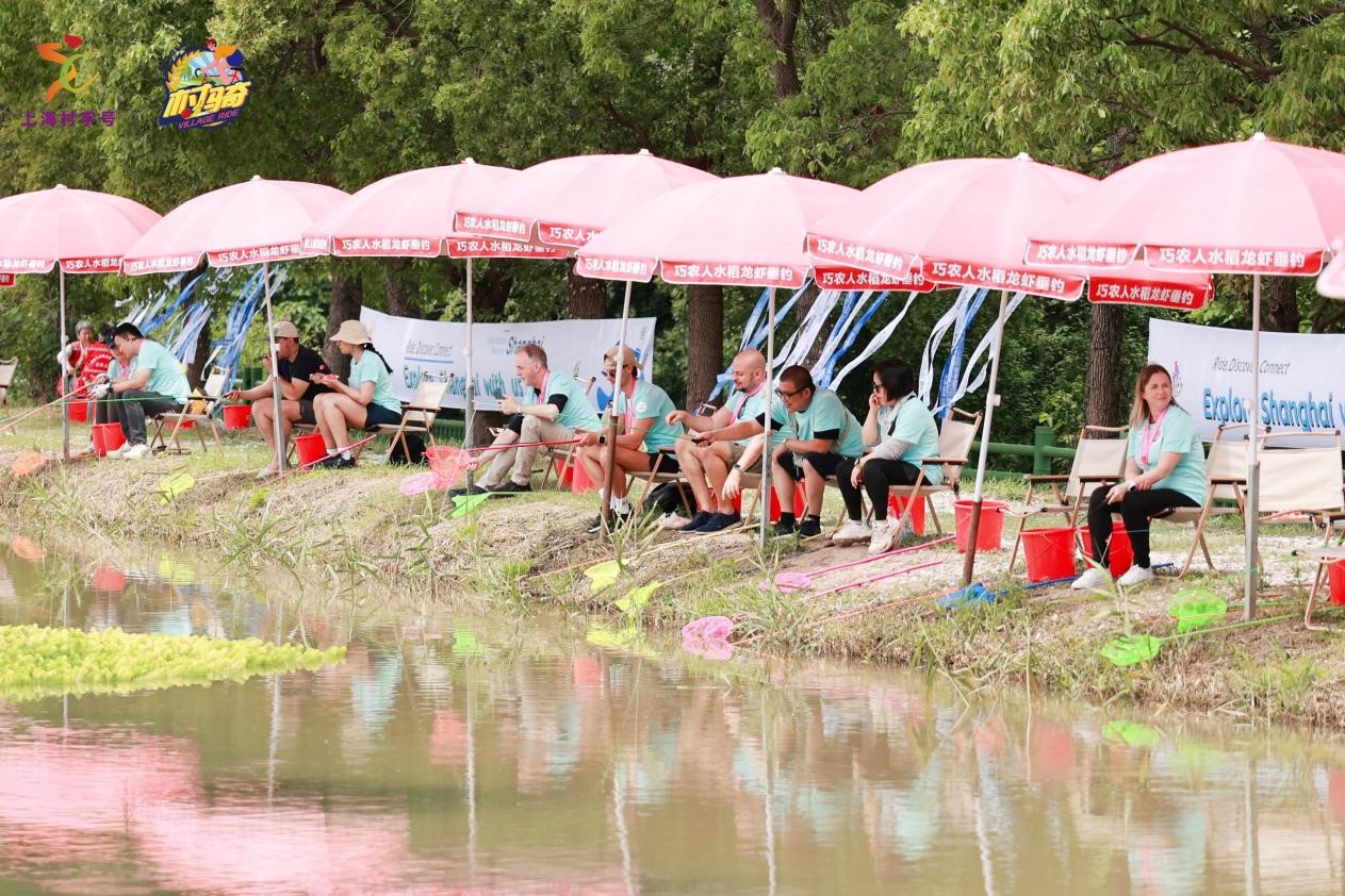 Los extranjeros disfrutan de un concurso de pesca de cangrejos de río junto a un estanque.jpg
