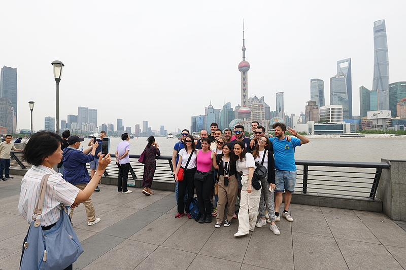Visitantes internacionales posan para tomar una foto grupal en el Bund de Shanghai.jpg