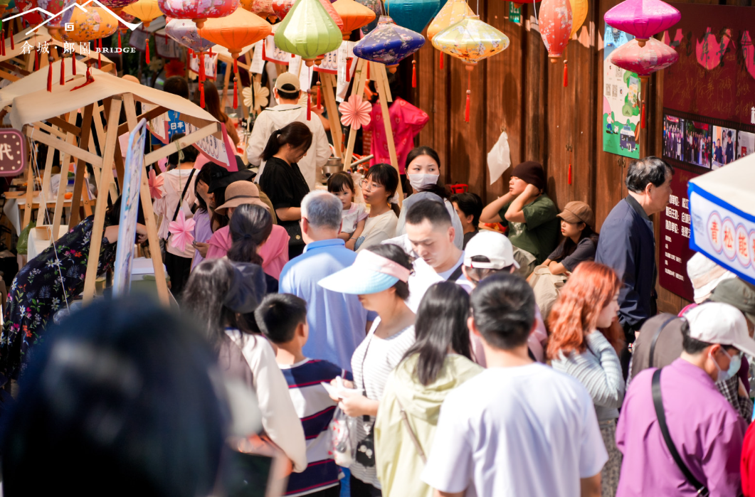 Turistas recorren los puestos en el puente Langyuan de Cangcheng.png