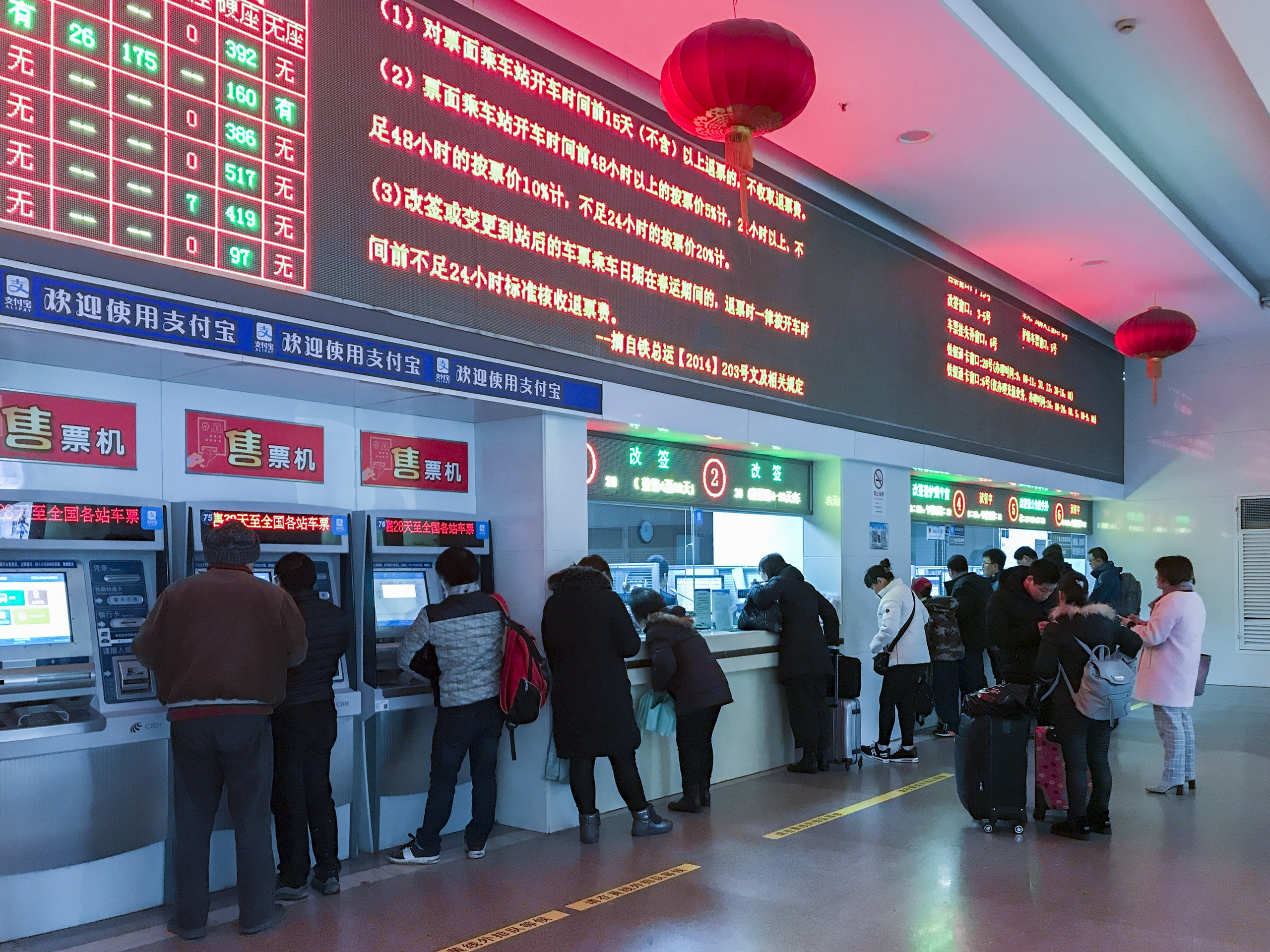 Los pasajeros compran boletos de tren en la taquilla de la Estación de Ferrocarril de Shanghai.jpg