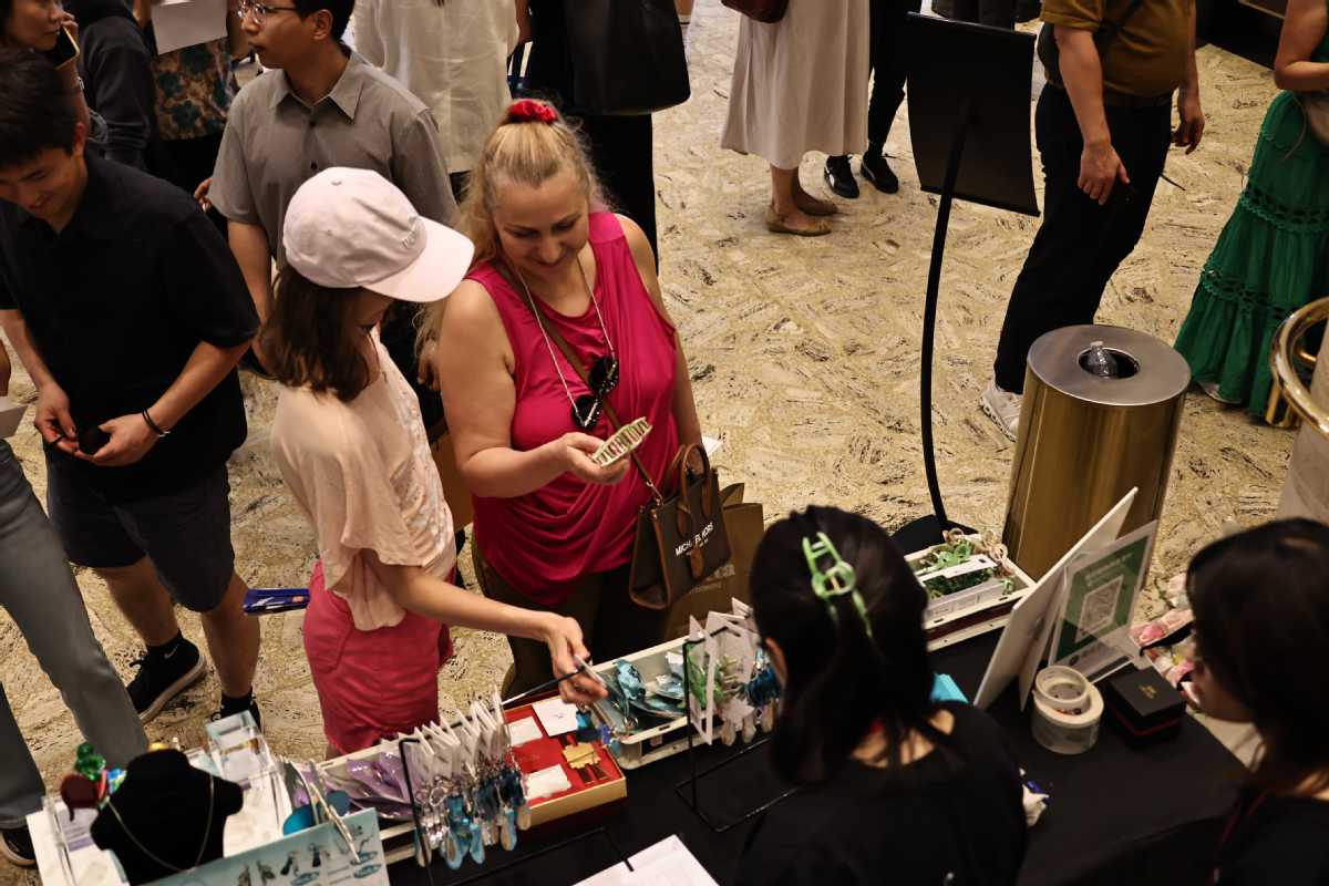 Los visitantes se detienen en un puesto del mercado de artesanos de la ciudad china durante el Día de Shanghai en el Centro Lincoln de Nueva York, el 26 de julio.jpeg