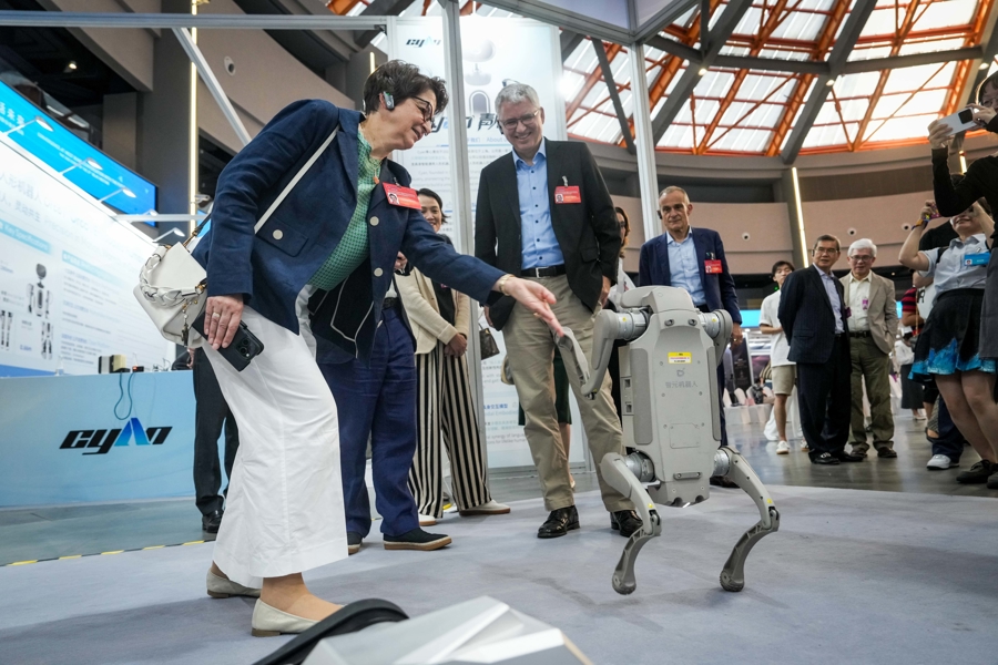 Empresarios interactúan con un perro robótico inteligente en West Bund, Shanghai, el 11 de octubre de 2025.jpg