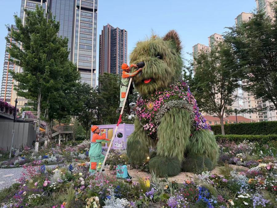 Trabajadores de jardinería realizan el trabajo de mantenimiento del topiario con forma de Westie.jpg