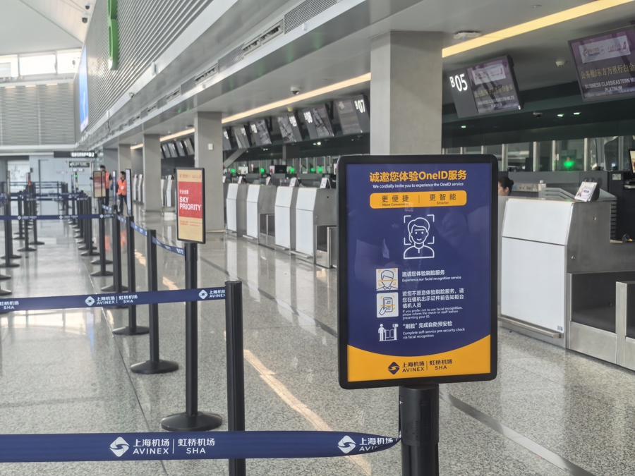 Un cartel de servicio One ID frente a un mostrador de facturación en el Aeropuerto Internacional Hongqiao de Shanghai..jpg