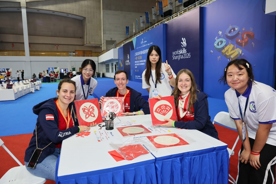Los miembros de la delegación austriaca muestran los recortes de papel que elaboraron en la Universidad Politécnica de Shanghai el 22 de septiembre.jpg