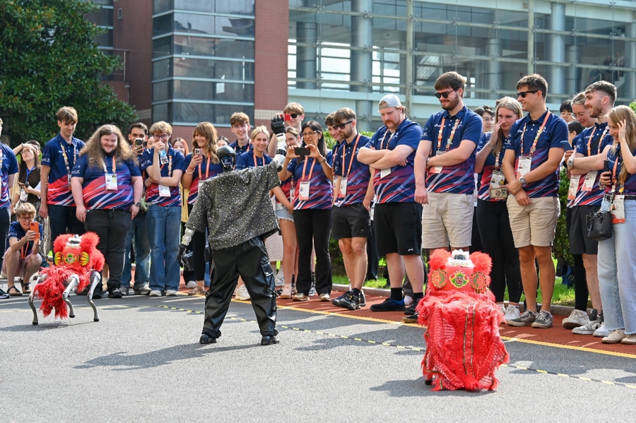 Miembros de la delegación del Reino Unido observan un robot y unos perros robóticos en el Colegio Xingjian de Shanghai el 22 de septiembre..jpg