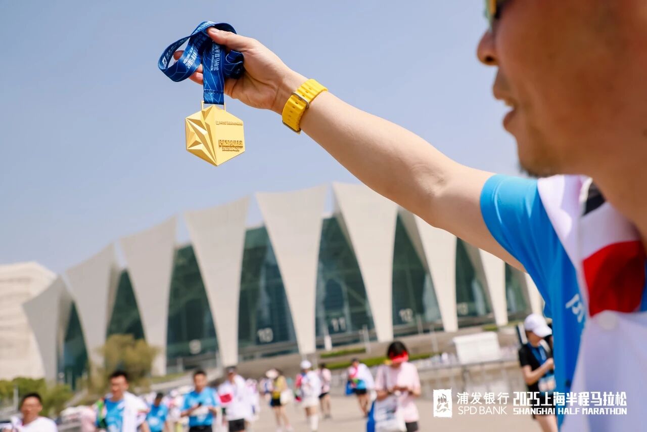 Un participante muestra su medalla del Medio Maratón de Shanghai..jpg