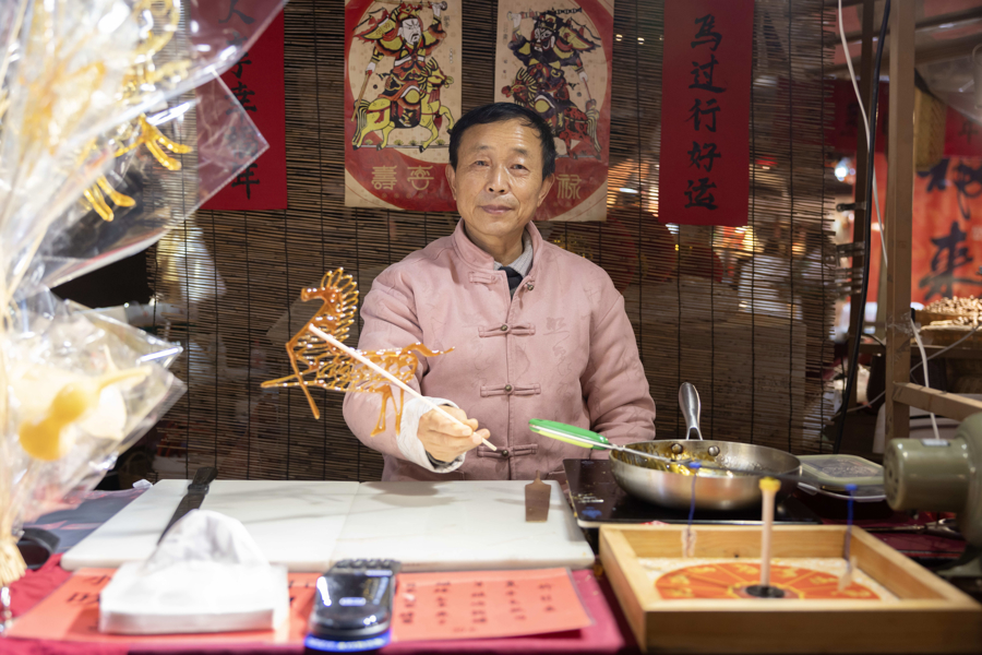 Un artesano exhibe una pintura de azúcar, un arte reconocido como patrimonio cultural inmaterial, en un mercado temático de la Fiesta de la Primavera de Panlong Tiandi..jpg
