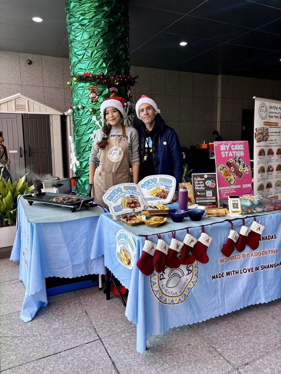 Zarmair Keshishian y Samantha Chan ante su estand de gastronomía argentina..jpg