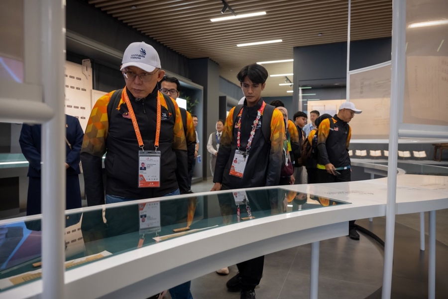 Los miembros de la delegación de Malasia observan exposiciones dedicadas a la restauración de libros antiguos y al calco de estelas en la Escuela de Gestión de la Información de Shanghai el 22 de septiembre..jpg