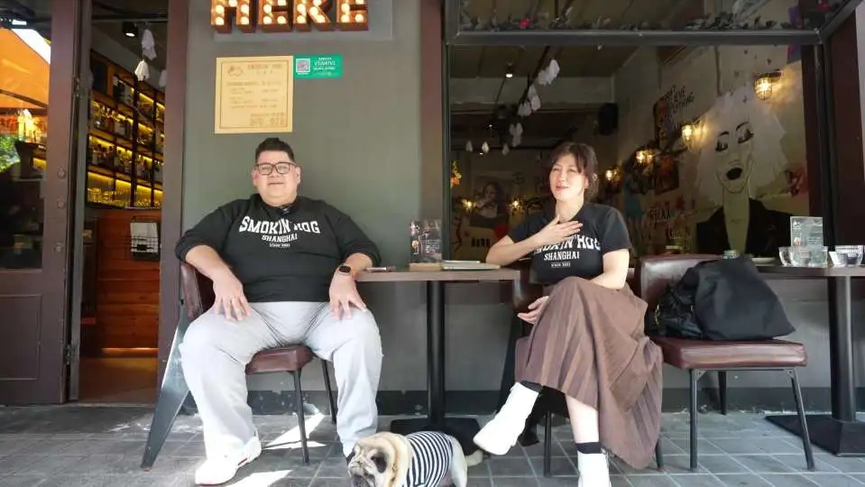 Ignacio y Karina sentados ante su restaurante Smokin